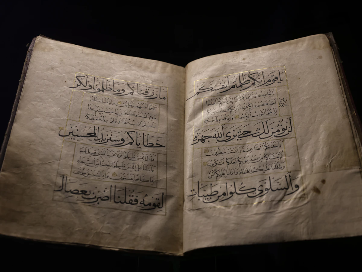 Naskah Al-Qur'an tulisan tangan di atas latar gelap