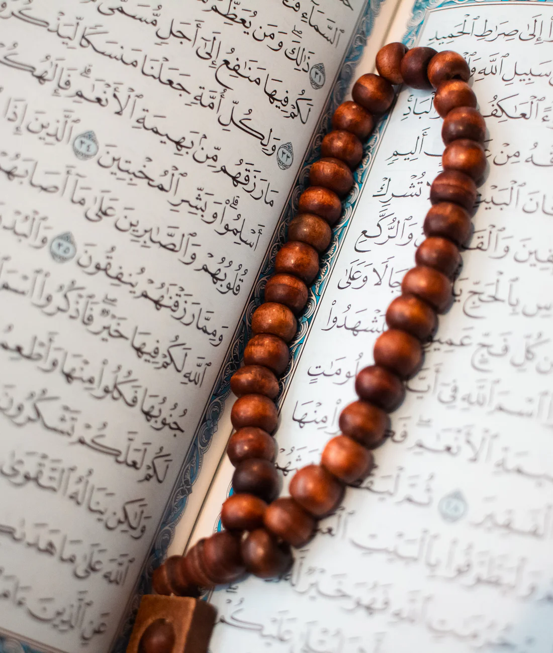 Al-Qur'an terbuka dengan tasbih di atasnya